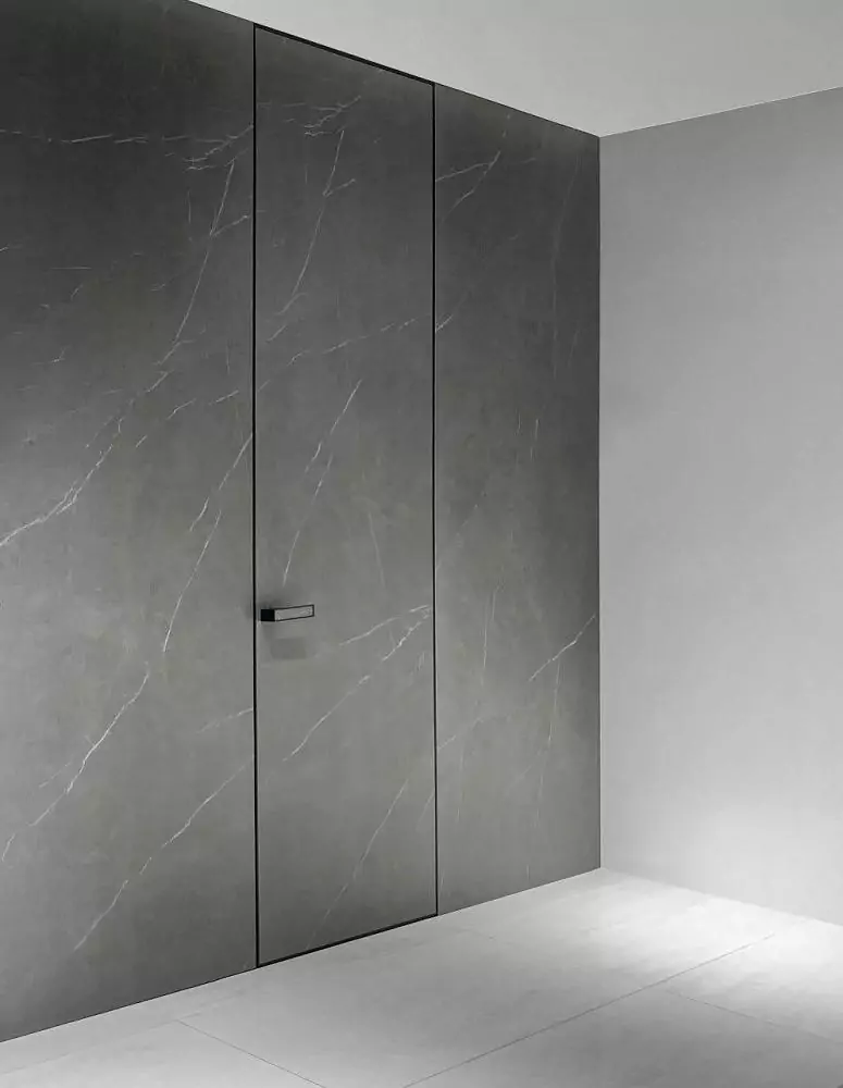 FILO–60, Alu, decorative composite material Marmo Grigio. Hidden door frame, aluminum end edge and handle in Black finish. The "under the ceiling" option.
