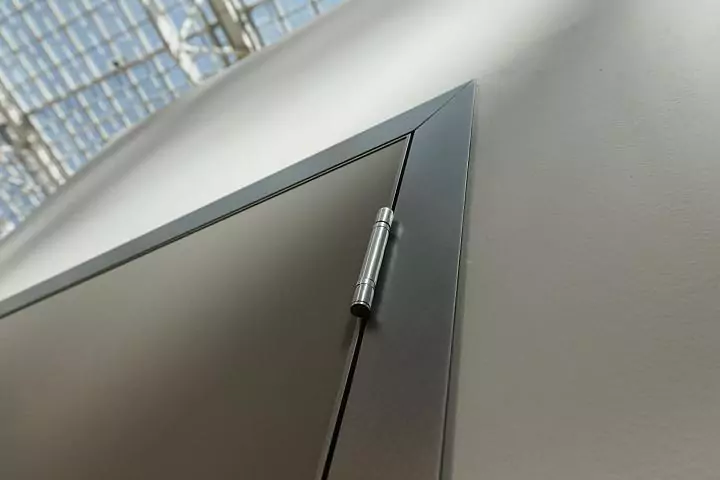 A fragment of a UNIX door. Matt enamel Grigio Seta. Aluminum profile of the canvas and a box with a platband in Piombo color. HAFELE loop.