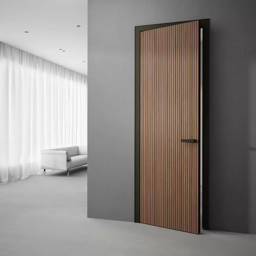 The door is UNIFLEX–3D, Alu, Step model, natural veneer Noce Canaletto. Aluminum monoblock door frame, end edge and handle in Dark Brown finish. Platbands without insert.