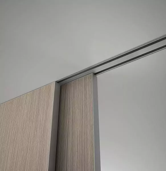 STRATUS-FILO, Alu, Velino model, natural veneer Rovere Canuto, end edge in Chrome Matt finish. Sliding double-leaf partition in the opening, hidden track in the ceiling. A fragment of canvases.