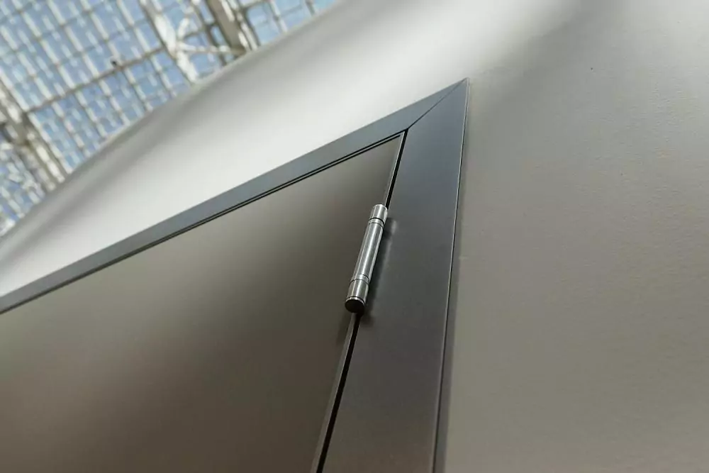 A fragment of a UNIX door. Matt enamel Grigio Seta. Aluminum profile of the canvas and a door frame with a platband in Piombo color. HAFELE loop.