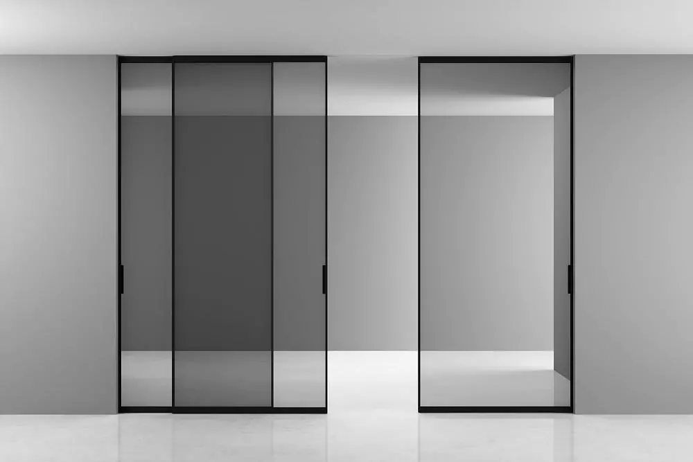 STRATUS–SLIM, translucent Trasparente Grafite glass, aluminum canvas frame in Black color. Sliding three–leaf partition in the opening, hidden track in the ceiling.